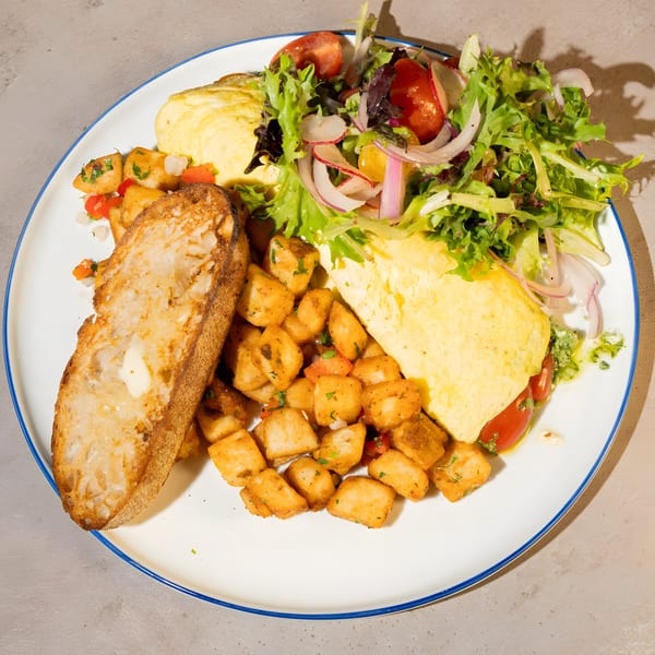 Bite Food & Coffee Co's breakfast plate with omelet, home fries, toast, and a fresh salad.