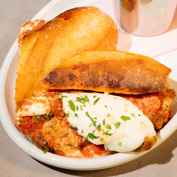 A chicken parmesan sandwich with melted mozzarella and marinara sauce on a toasted bun.